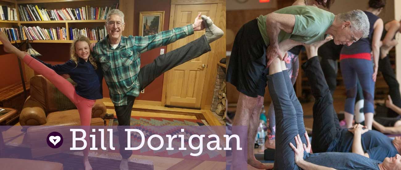 Bill Dorigan in hand to big toe pose wearing a plaid shirt with his grand daughter