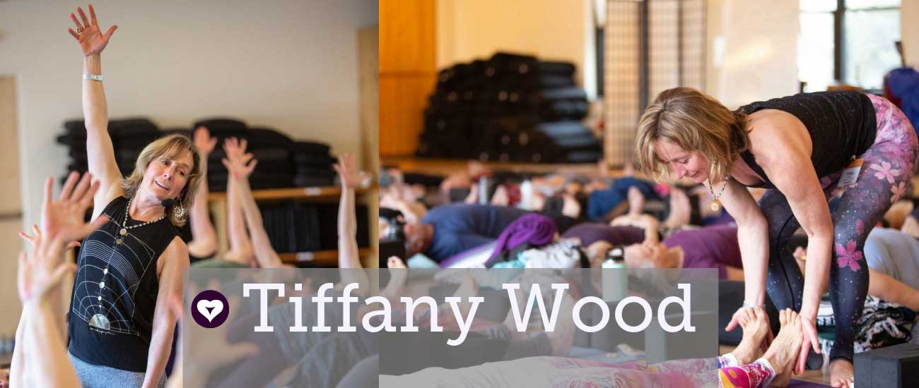 tiffany wood met haar arm in de lucht en assisterende savasana