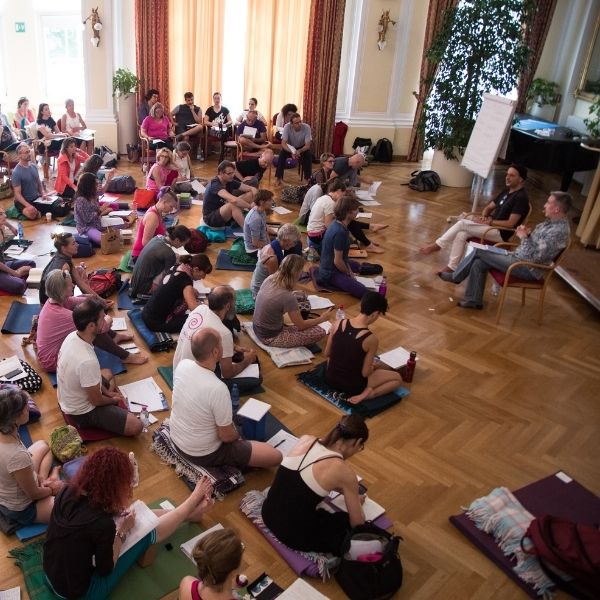 des professeurs de yoga anusara et des étudiants écoutant carlos pomeda parler de philosophie