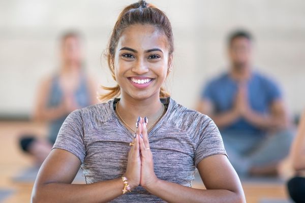 vrouw die yoga beoefent met handen in gebedspositie en haar innerlijke stabiliteit voelt